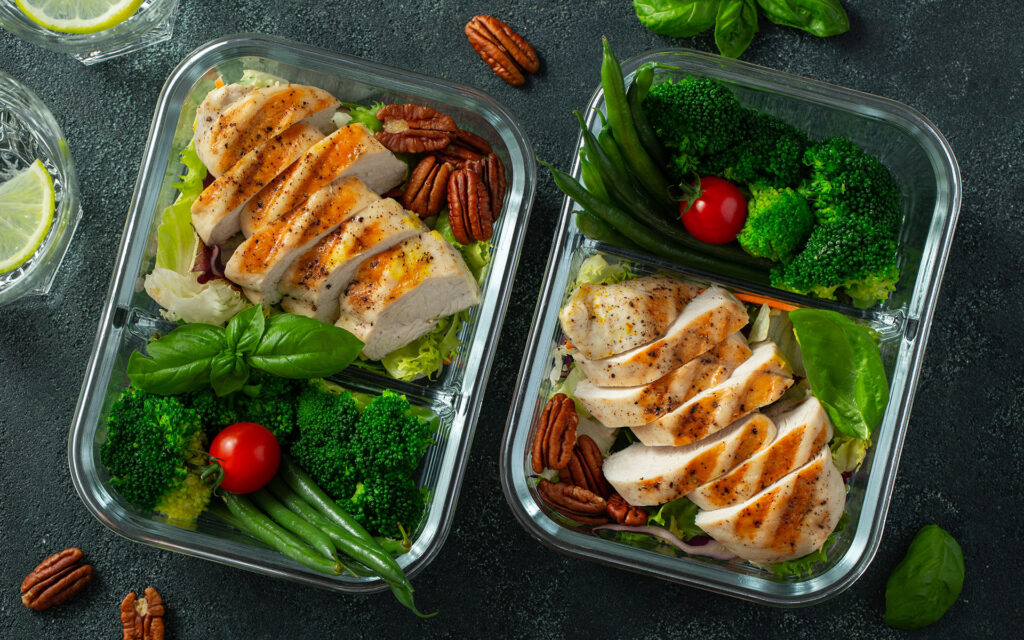 Healthy meal prep containers with green beans, chicken breast and broccoli. Meal prep for controlling body fat percentage